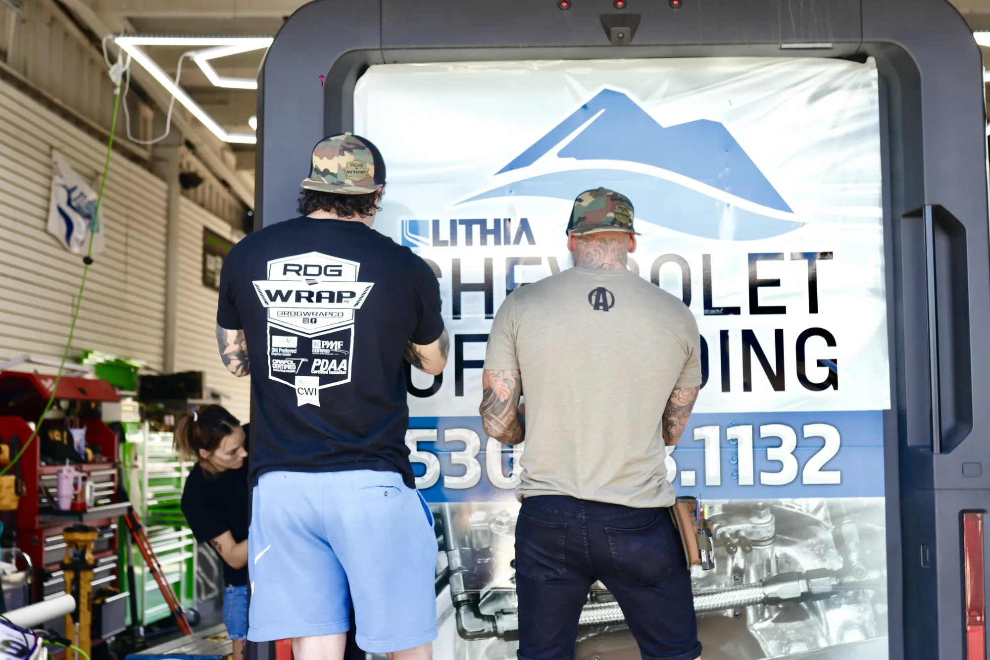 Installers wrapping a Lithia Chevrolet of Redding vehicle in the shop