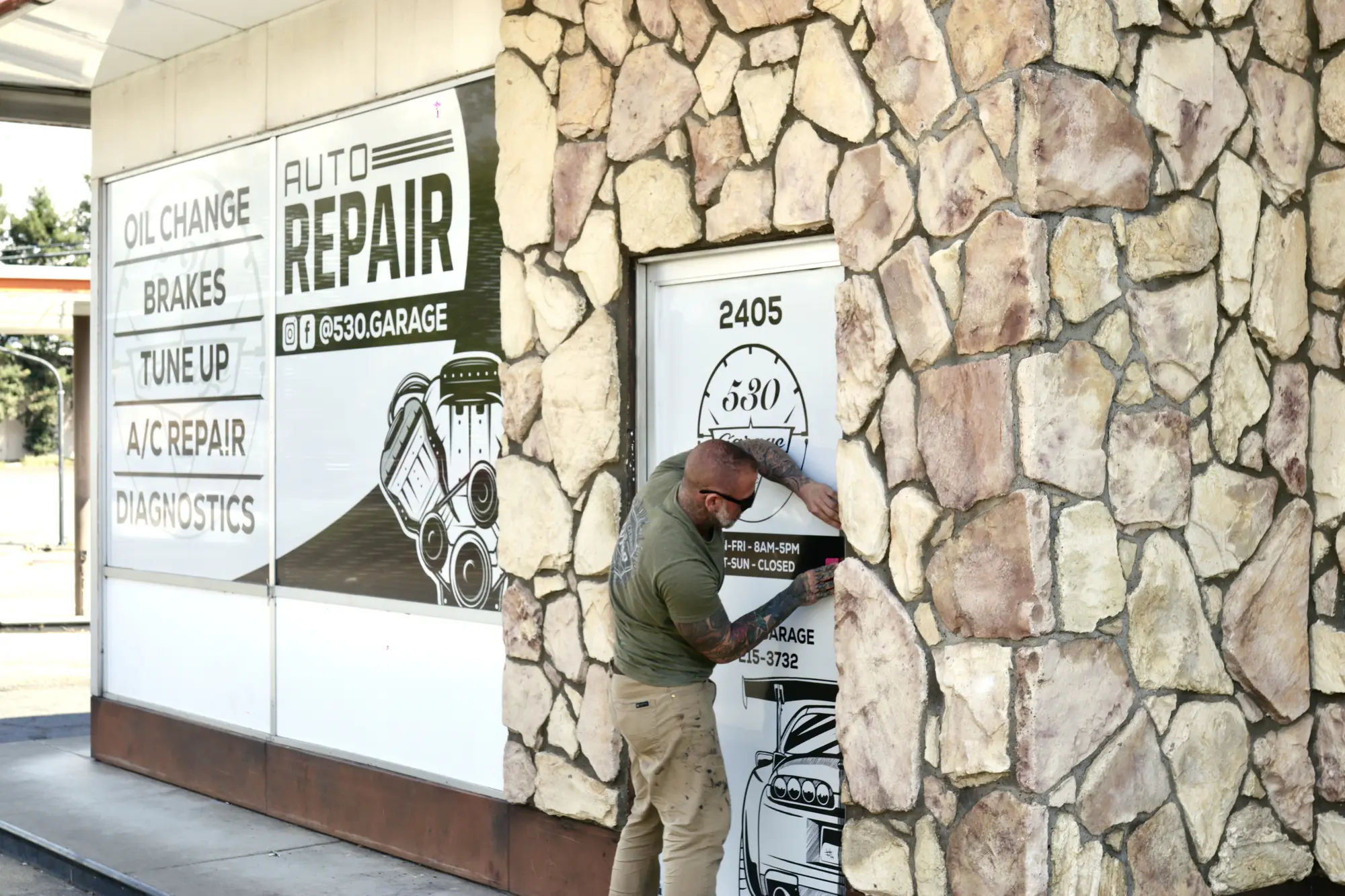 Installer applying door graphics at 530 Garage
